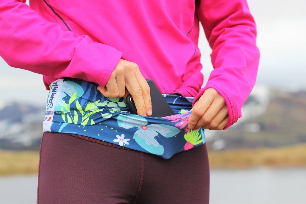 une femme qui range son téléphone dans une running belt