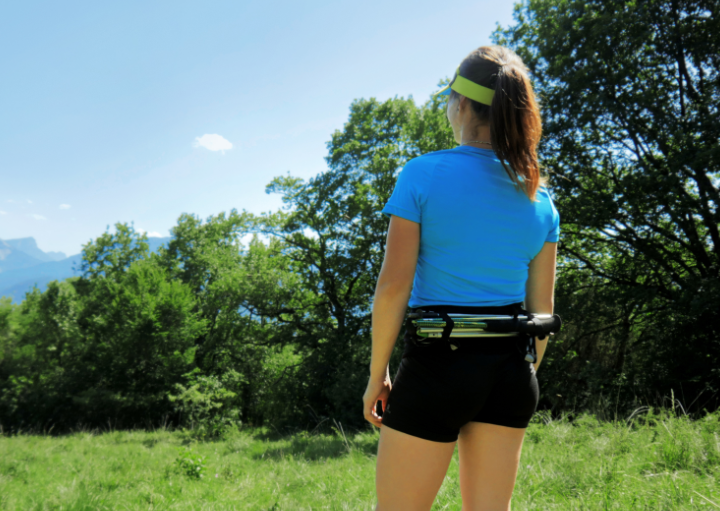 Anaïs Chevalier portant la running belt Sammie Trail avec des bâtons accrochés dans le dos