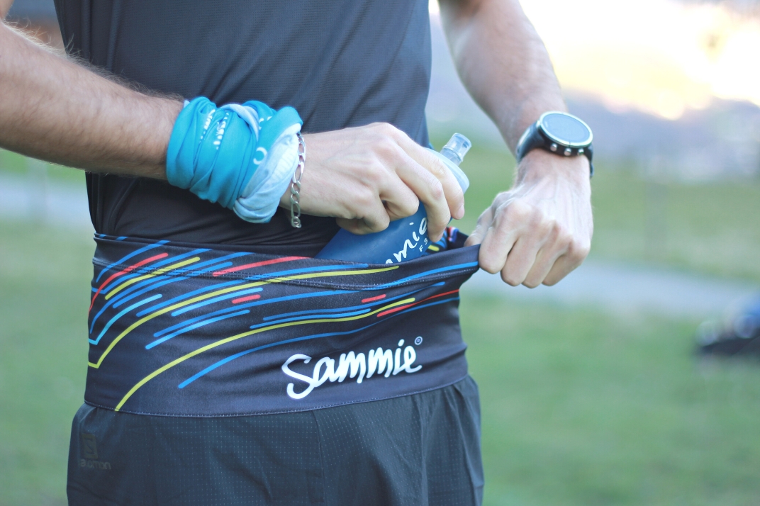 Un homme qui met une gourde dans une ceinture sammie