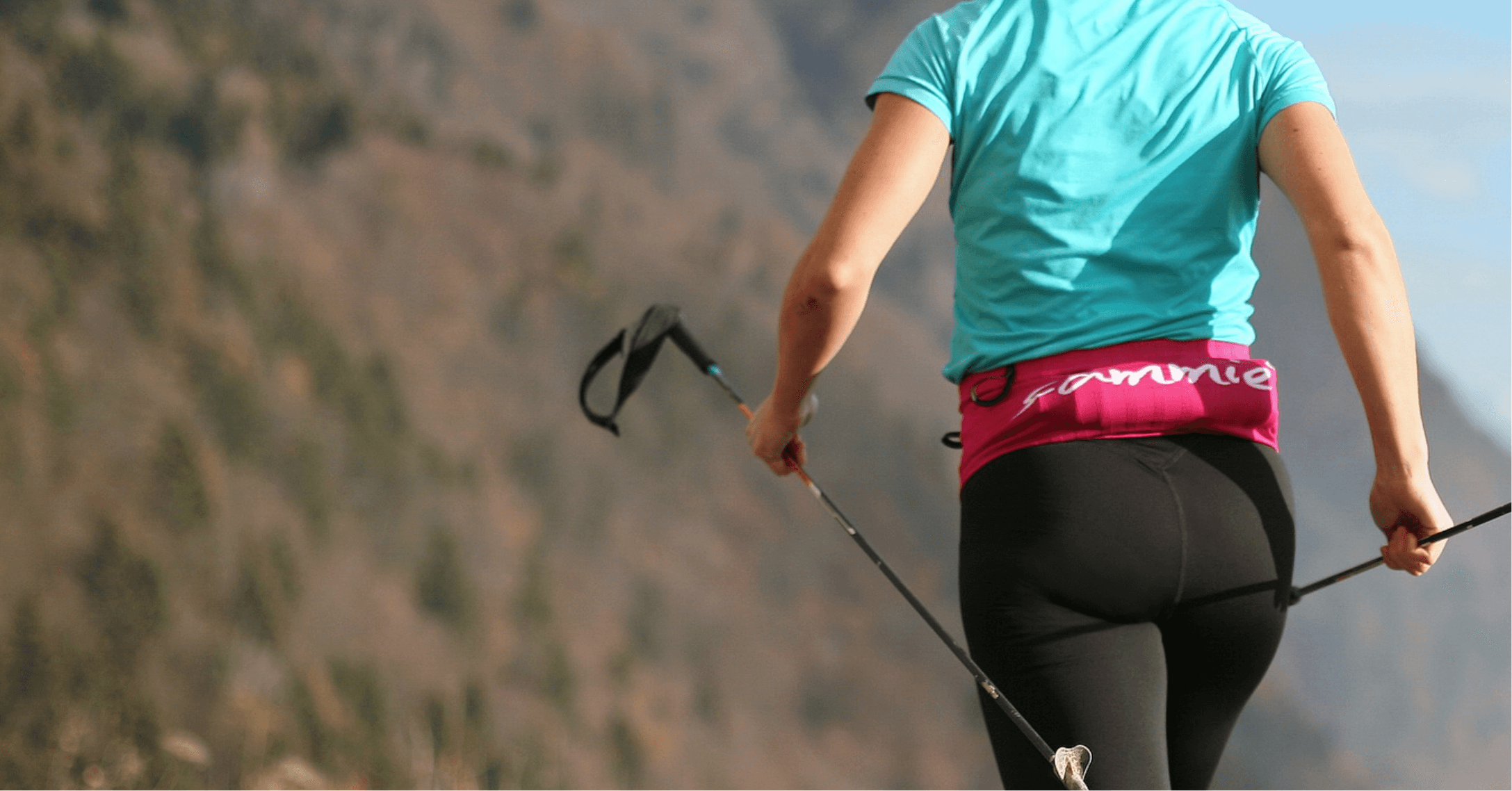 Une sportive portant la Sammie® V2 remplie avec une gourde souple pendant une run le long d'une crête en montagne