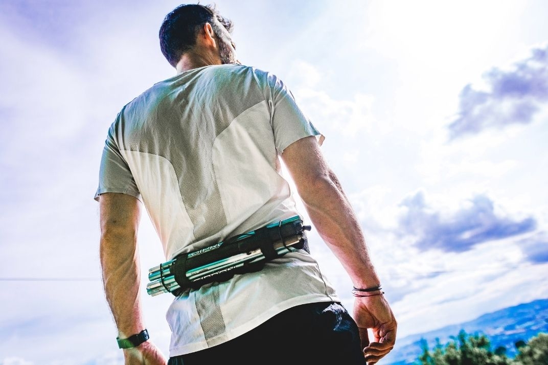 homme qui porte la ceinture porte bâtons trail