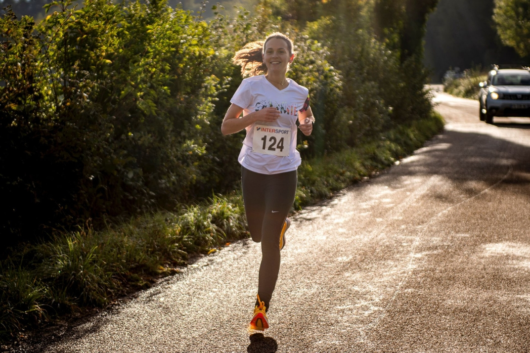 Une femme qui court avec le t-shirt anti transpirant pendant une compétition