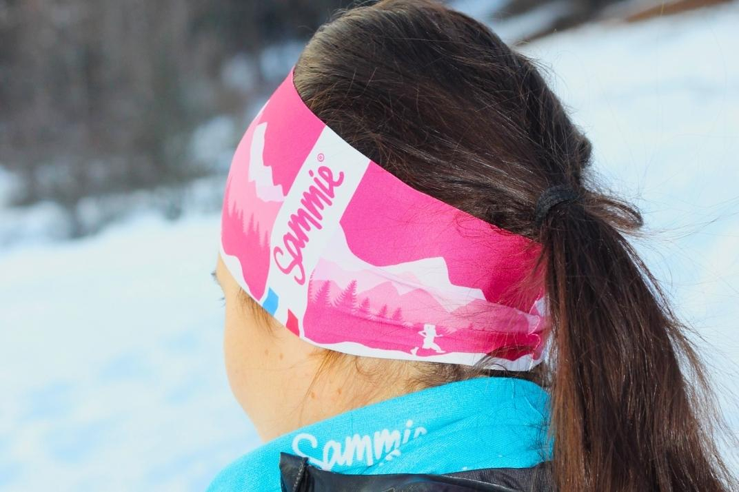 Une femme sportive avec le bandeau femme à la montagne l'hiver
